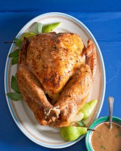 a whole chicken sitting on top of a white plate next to a cup of coffee