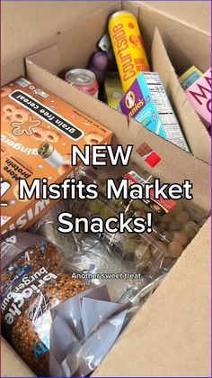 an open box filled with snacks on top of a wooden table and the words new misfits market snacks