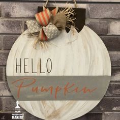 a wooden sign that says hello pumpkin hanging on a brick wall