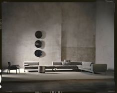 a living room filled with lots of furniture next to a wall mounted disc art piece