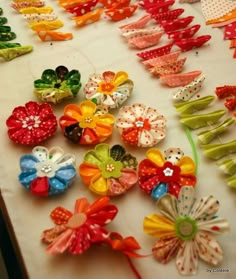 many different colored flowers on a table with polka dot dots and ribbons attached to them