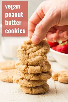 vegan peanut butter cookies stacked on top of each other with strawberries in the background