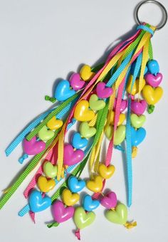 a bunch of heart shaped lollipops tied to a keychain on a white surface