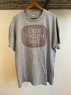 "Vintage 90's faded Alstyle Old English 800 T-shirt. Size large. 90% cotton 10% polyester. 22\" armpit to armpit. 29\" long" Vintage Pre-washed Cotton T-shirt, Vintage Faded T-shirt Pre-washed, Vintage Faded T-shirt With Screen Print, Vintage Acid Wash Pre-washed T-shirt, Oversized Acid Wash Vintage T-shirt, Vintage Gray T-shirt With Text Print, Vintage Style Relaxed Fit Faded Tops, Vintage Gray Summer T-shirt, Vintage Oversized Crew Neck T-shirt