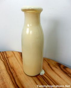 a white vase sitting on top of a wooden table