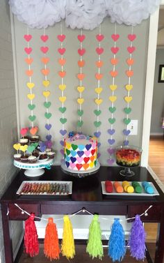 a table with cake, cupcakes and decorations on it in front of a wall