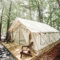 a tent in the woods with a chair