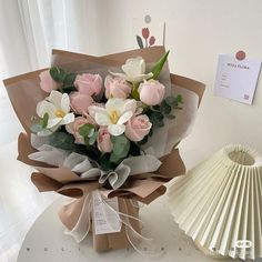 a bouquet of flowers sitting on top of a table next to a fan and paper fan