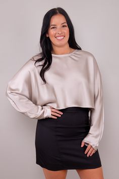 Crafted from the finest satin, this blouse exudes a luxurious allure that's hard to resist. The silky-smooth fabric drapes gracefully, and the long sleeves add a touch of classic charm. The cropped length is not only on-trend but also versatile, allowing you to pair it with high-waisted skirts, pants, or jeans for a look that's both chic and contemporary. Whether you're dressing up for a special occasion or elevating your everyday style, this blouse is your go-to choice. Its simplicity is its st Elegant Long Sleeve Top For Evening, Chic Long Sleeve Satin Top, Elegant Long Sleeve Top For Fall, Sleek Long Sleeve Top For Evening, Silk Tops For Night Out In Fall, Fall Solid Silk Tops, Evening Long Sleeve Blouse, Beige Silk Blouse For Evening, Long Sleeve Solid Color Blouse For Night Out