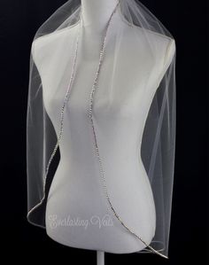 a white mannequin with a veil and necklace on it's neckline