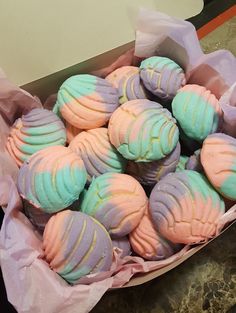 a box filled with colorfully decorated cookies on top of a table