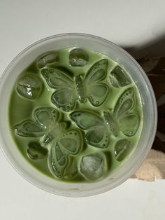 a bowl filled with green liquid next to a piece of bread