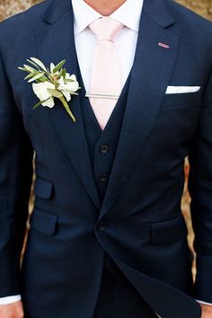 a man in a suit with a flower on his lapel