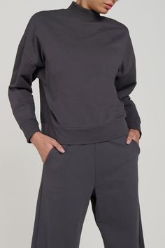 The Zen Mock Neck Sweatshirt, part of a matching set. Made from 95% organic cotton and 5% spandex. The organic French Terry fabric is not only comfortable, but also environmentally friendly. The crewneck design gives a timeless and classic. This sweater is perfect to match with the Bio Terry Pants or Bio Terry Joggers. Available in Carbon and Black. Product Features: FIT: The Zen Mock Neck Sweatshirt is soft, comfortable, with a relaxed fit. Features: Super soft organic terry cotton fabric, crew Organic Cotton Long Sleeve Tops For Loungewear, Athleisure Tops With Ribbed Collar For Loungewear, Funnel Neck Sweatshirt For Layering, Funnel Neck Stretch Sweatshirt For Layering, Stretch Sweatshirt With Funnel Neck For Layering, Stretch Funnel Neck Sweatshirt For Layering, Athleisure Funnel Neck Sweatshirt For Layering, Relaxed Fit Crew Neck Top With Ribbed Neckline, Cozy Fit Basic Top For Loungewear