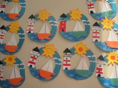 the wall is decorated with paper cut out of boats, lighthouses and sunbursts