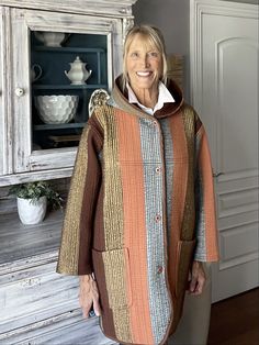 "Sunset"   is a one of a kind, upcycled duster/coat made by Award Winning Quilter Karen Carns of Market Street Quilts. This super cozy duster/coat was created from a lovely quilted comforter. All seams are finished, front pockets, comfortable hood with a front button closure. Perfect coat for chilly outings and get ready to receive a lot of compliments. Fits a US Misses Large with finished bust measurement of 48", arm length of 25" and length of 35". I will shorten sleeve length at no charge, if necessary. Machine wash/dry, Made in a smoke free studio in Arizona. Quilted Comforter, Quilt Coat, Perfect Coat, Market Street, Halloween Shopping, Duster Coat, Award Winning, Arizona, Art Collection