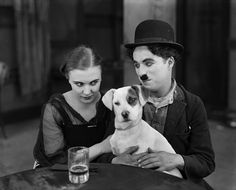 a man and woman sitting at a table with a dog