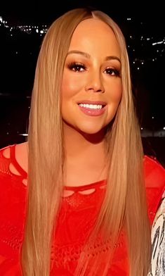 a woman with long blonde hair smiling at the camera