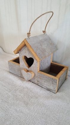 a wooden birdhouse with a heart in it