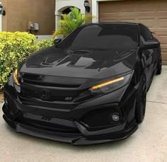 a black sports car parked in front of a house