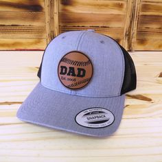 Celebrate the dads who love baseball with this custom laser engraved dad established date baseball leather patch hat. The hats are the popular trucker style snap-back that look great and are available in several colors - see available colors. Shipped in a full size box so you will receive your hat in perfect condition.  Looking for something different? We can make any custom patch for you, just message us! Item Care: Spot clean only. Do not machine wash or dry. As this item is a custom made item, refunds and returns are not offered. If there is a problem with the order please contact us and we will help to resolve. Hat Details: Material: 65% polyester and 35% cotton Size: Adult with snapback adjustable. Patch Details: Vegan friendly leatherette patch Great for: Baseball Dad Baseball Papa G Adjustable Six-panel Trucker Hat For Baseball Season, Trucker Baseball Cap With Curved Visor For Baseball Season, Trucker Style Baseball Cap With Curved Visor, Trucker Dad Hat With Curved Bill For Baseball Season, Baseball Season Snapback Hat With Logo Patch, Trucker Baseball Cap For Baseball Season, Trucker Snapback Hat With Curved Bill For Baseball Season, Outdoor Fitted Hat For Baseball Season, Father's Day Trucker Hat Snapback