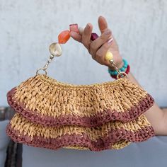 a woman's hand holding a straw purse