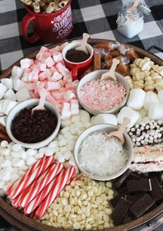 a platter filled with marshmallows, chocolate and candy canes