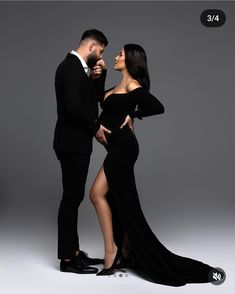 a man and woman in formal wear standing next to each other