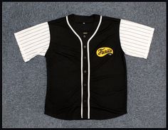 a black and white baseball jersey with the word pittsburgh on it's chest, in front of a gray background