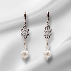 Elegant Art Deco, Edwardian style drop earrings with antiqued silver connector and lever back ear wires, gracefully show the stunning white pearl glass bead and dainty clear crystal bicone bead,  Capturing the grace of the Bridgerton period these earrings would complement any dress occasion, from your special day to casual wear.  Each earrings has a 55mm drop. Classic Bridal Earrings For Evening, Elegant Bridal Earrings With Intricate Design For Evening, Classic Filigree Earrings, Victorian Style Pierced Earrings For Wedding, Classic Formal Chandelier Earrings With Intricate Design, Vintage Silver Pearl Earrings For Wedding, Victorian Wedding Earrings With Intricate Design, Ornate Silver Pearl Earrings For Formal Occasions, Victorian Silver Bridal Earrings For Formal Occasions