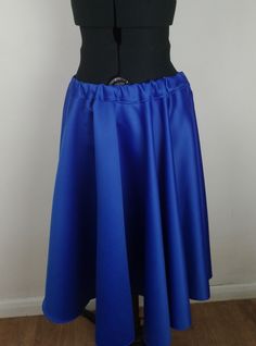 Elevate your wardrobe with this stunning royal blue duchess satin circle skirt from Polly Perkins Clothing and Accessories. The plus size L skirt features an elasticated waist for a comfortable and flattering fit, with a knee-length and flare style that is perfect for any occasion. Whether you're attending a wedding, party, or just running errands, this skirt is sure to turn heads with its stylish design and vintage charm.  Crafted from high-quality duchess satin fabric, this skirt is both durab Stretch Satin Flared Skirt Bottoms, Satin Stretch Midi Skirt, Stretch Satin Lined Skirt, Stretch Satin Midi Skirt, Fitted Blue Satin Bottoms, Blue Fitted Satin Bottoms, Satin Stretch Flared Skirt, Blue Fitted Satin Skirt, Stretch Satin Flared Skirt