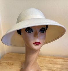 This classic Ivory wool felt lampshade hat has a 4 1/2 inch brim all around. The hat will fit up to a 22- 22 1/2  inch head size. The ivory grosgrain ribbon is removable if you would like to put another band on. NOTE: Please check the head size before purchase, I am happy to answer any questions you may have. There will be a 20% restocking fee for all returned hats. White Brimmed Felt Hat For Kentucky Derby, Classic White Felt Hat With Short Brim, White Brimmed Felt Hat For Formal Occasions, White Wide Brim Felt Hat For Formal Occasions, Classic White Mini Hat With Curved Brim, White Classic Mini Hat With Curved Brim, Vintage White Fedora With Short Brim, Elegant White Brimmed Felt Hat, Classic White Mini Hat With Wide Brim