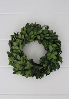 a close up of a wreath on a wall with white boards in the back ground