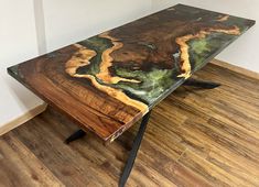 a wooden table sitting on top of a hard wood floor next to a white wall