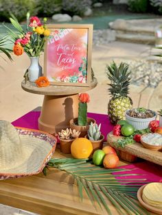 a table with pineapples, oranges and other fruit on it is shown