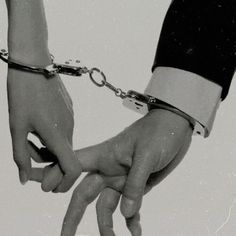 black and white photograph of two people holding hands with chains attached to each other's wrists