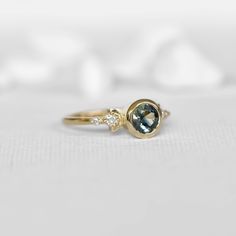 This unique design of modern boho 0.85c parti sapphire engagement ring is truly magical. Inspired by the moon shapes of its orbit cycle, it features a stunning round natural multi-colored parti sapphire captured in a raw bezel circle setting. The 14k yellow gold band is designed with two decorative side boho half moons and 4 side diamonds, making this beauty a one to remember! Perfect for the modern bohemian bride, this ring is sure to be a conversation starter. Sapphire Topaz Ring With Rose Cut Diamonds, Topaz Sapphire Ring With Rose Cut Diamonds, Sapphire Rings With Rose Cut Diamonds, Sapphire Birthstone Ring With Rose Cut Diamonds, Sapphire Ring With Rose Cut Diamonds, Modern Sapphire Ring With Rose Cut Diamonds, Round Sapphire Ring With Rose Cut Diamonds, Celestial Style Sapphire Ring For Anniversary, Blue Topaz Diamond Ring With Rose Cut Diamonds