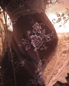 a pregnant woman's belly is covered in lacy fabric and lace, with flowers on it