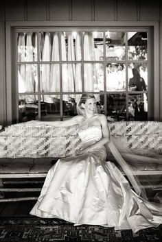 a woman in a wedding dress sitting on a bench