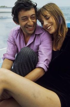 a man sitting next to a woman on top of a boat