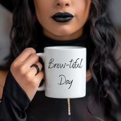 a woman holding a coffee mug with the words brew - tiful day written on it