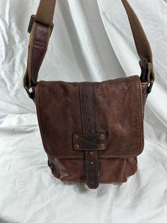 Measurements are 10" wide, 10"4 high and 2"5 deep with a 53" shoulder strap with a 25" drop. One inner compartment lined in fabric, back zipper pocket, back pocket, top zipper closure along with brass hardware, two exterior pockets and bag can be used cross body. There are a few light scuffs with no tears and looks amazing. Bag is great for work, school and travel. 100% genuine Fossil.  -----------------------------------------I SHIP WORLDWIDE------------------------------------------------- I w Vintage Bags With Adjustable Strap For Fall, Brown Crossbody Satchel For Travel, Travel Brown Crossbody Satchel, Brown Leather Lined Hobo Shoulder Bag, Vintage Crossbody Bag For Fall, Brown Leather Shoulder Satchel, Vintage Brown Bag For Fall, Brown Saddle Bag With Leather Lining And Flap, Brown Leather Saddle Bag With Flap And Leather Lining