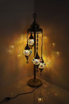 a lamp that is on top of a table with many lights around it and some balls hanging from the ceiling