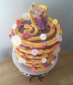 there is a cake that looks like it has been decorated with flowers and a princess figure on top