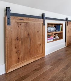 a room with wooden floors, sliding doors and bookshelves on the wall behind them