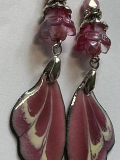 Handmade OOAK dangle earrings made with ARTISAN ENAMELED WINGS CHARMS by Sabrina Designs, a Lampwork bead artist. I also used Czech glass and glass beads and silver metal findings to complete these earrings. They are about 2.75" dangle. Handmade Iridescent Metal Earrings, Whimsical Silver Resin Jewelry, Artistic Nickel-free Purple Jewelry, Artistic Purple Nickel-free Jewelry, Handmade Iridescent Dangle Earrings, Pink Teardrop Beads For Jewelry Crafting, Pink Teardrop Jewelry Beads For Crafting, Teardrop Pink Jewelry For Crafting, Handmade Pink Glass Jewelry