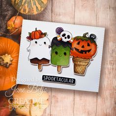 a card with three halloween characters on it and pumpkins in the background next to it