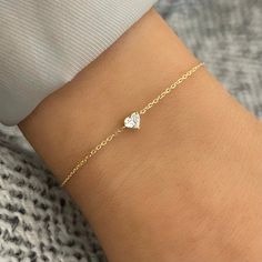 A delicate 18k Gold chain houses a diamond heart pendant that glimmers and gleams along the wrist. Give it as a gift or wear it yourself, we know you'll adore the Lover Diamond Heart Bracelet! An adjusting sliding bead allows the option for versatile lengths of wear. The intentional delicacy of this design makes for the heartfelt gift of a child's first piece of fine jewelry or an adult's everyday dainty wear. Try pairing this with our Lover Diamond Heart Necklace. Metal: 18k White Gold / 18k Yellow Gold Round Brilliant Cut Natural Diamonds: Approx. 0.21 ctw G/H Color and SI Clarity Diamonds Length: Adjustable sliding bead to provide options for the length. 7" at the longest. Closure: Lobster claps Looking for a different size? Please email us. Diamond Heart Necklace, 18k Gold Chain, The Lover, Heart Necklace Diamond, Big Diamond, Heart Pendant Diamond, Bridal Bands, Ring Fit, Fine Jewelry Collection