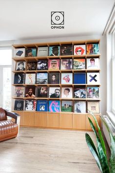 a living room with a book shelf filled with books and vinyl records on the wall