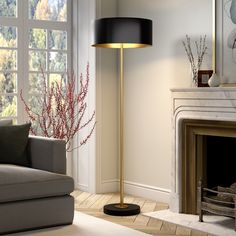 a living room scene with focus on the floor lamp and fire place in the fireplace